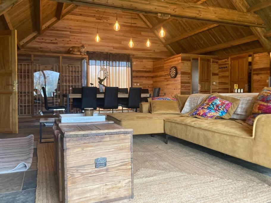 ein Wohnzimmer mit 2 Sofas und einem Esszimmer in der Unterkunft Le Chalet du Renard in Le Tampon