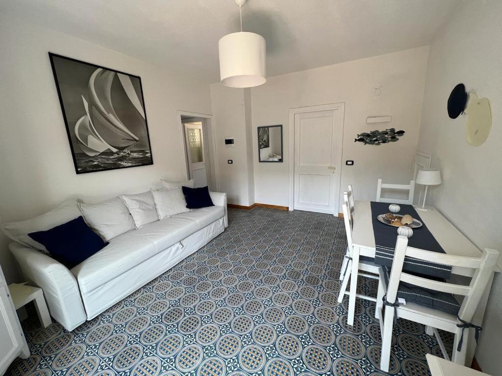 uma sala de estar com um sofá branco e uma mesa em La casetta a Fiumicello em Maratea