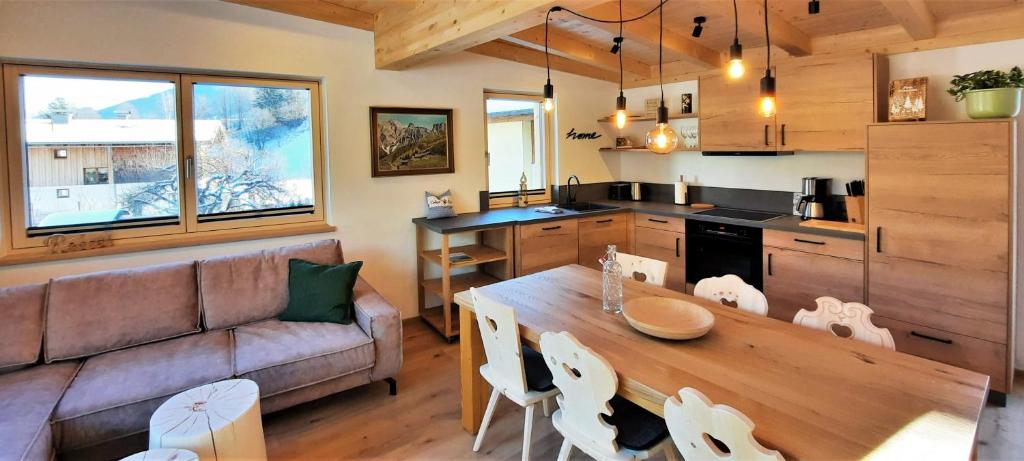een keuken en een woonkamer met een tafel en een bank bij vomLandl Natur Lofts & Apartments Leogang in Leogang