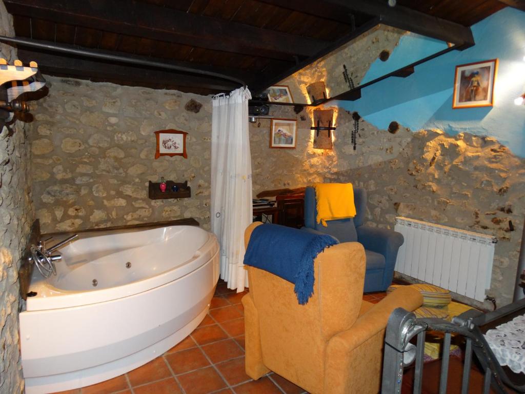 a bathroom with a large tub and a chair at Casa La Cantonera con zona relax jacuzzi in La Cuba