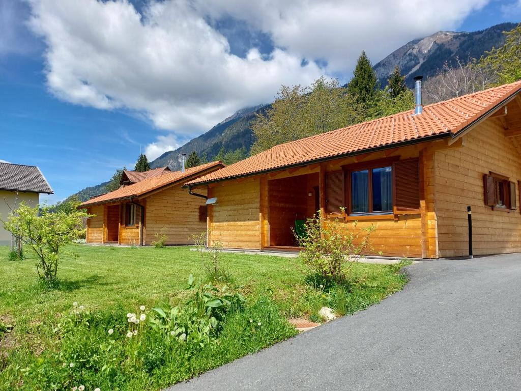 a log cabin with a grassy yard next to a house at Chalet Stressless in Presseggen