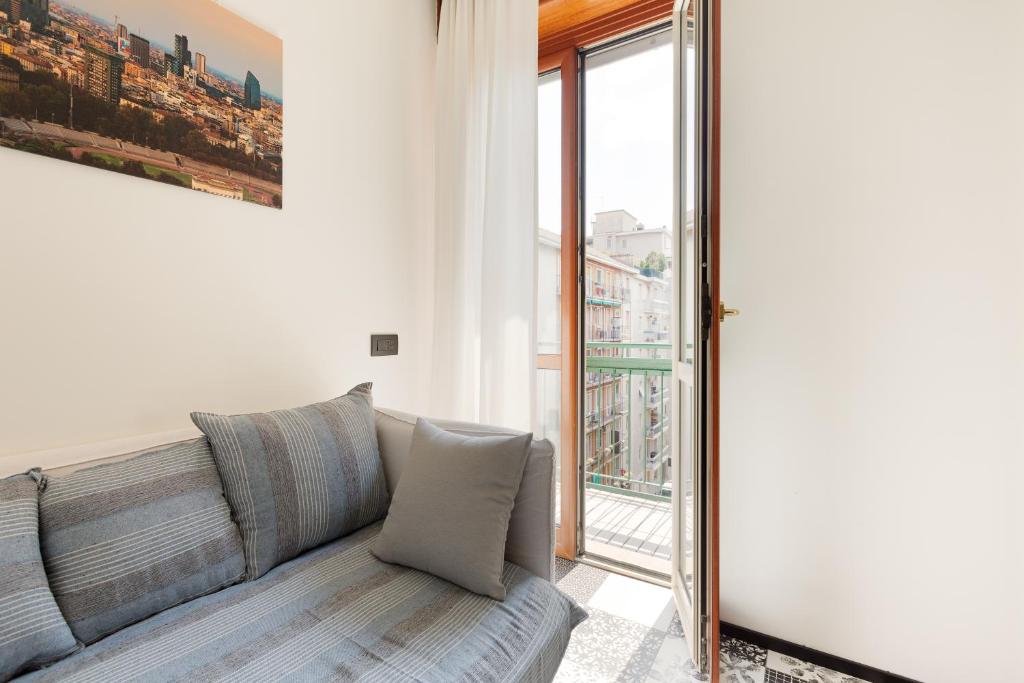a living room with a couch and a large window at Milano Renovated Studio APTS in Milan