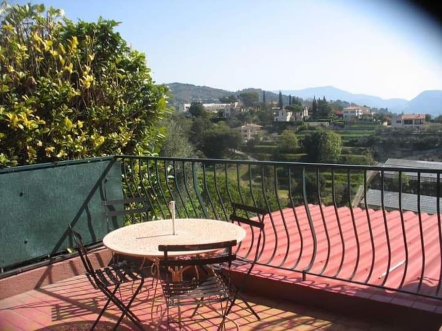 une table et des chaises assises sur un balcon dans l'établissement Maison traditionnelle sur les collines Niçoises, à Nice