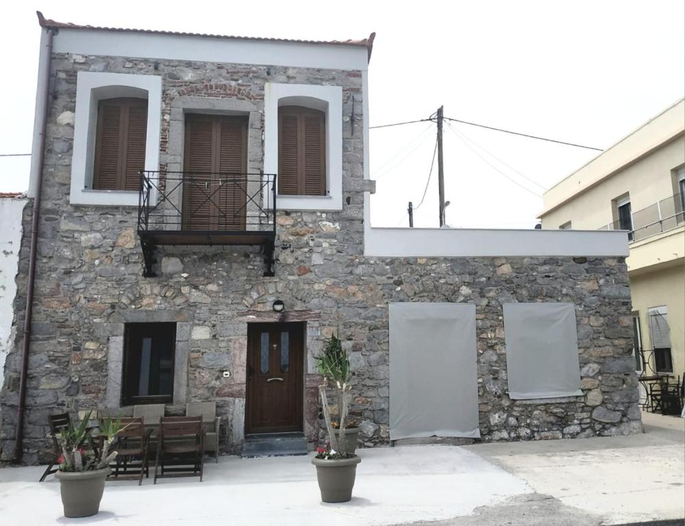 a stone building with a door and a balcony at Two-storey house in Kardamyla in Mármaron