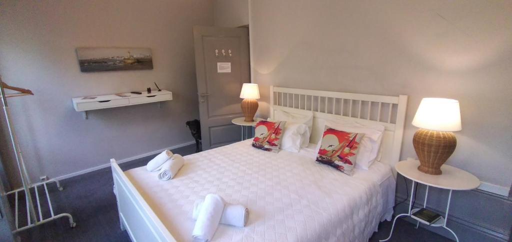 een slaapkamer met een groot wit bed met kussens bij Guest House Antero de Quental in Porto