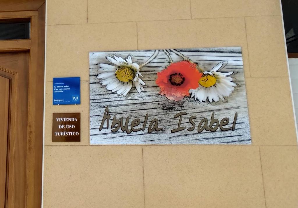 a sign on a wall with flowers on it at La abuela Isabel Piso con encanto Arnedillo in Arnedillo