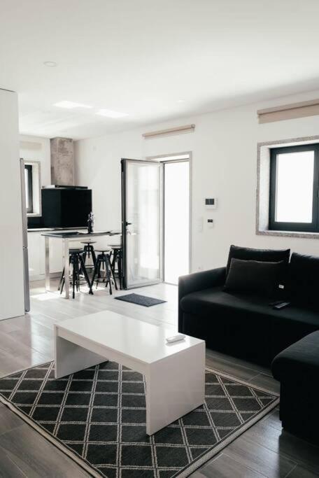 uma sala de estar com um sofá preto e uma mesa em Vale Do Mar House em Espinho