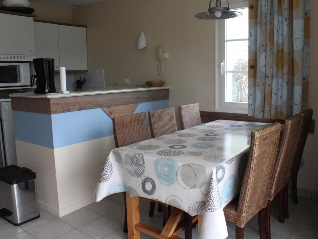 une cuisine avec une table recouverte d'une nappe dans l'établissement Maison familiale à Belle Dune, proche plage et golf - FR-1-482-64, à Fort-Mahon-Plage