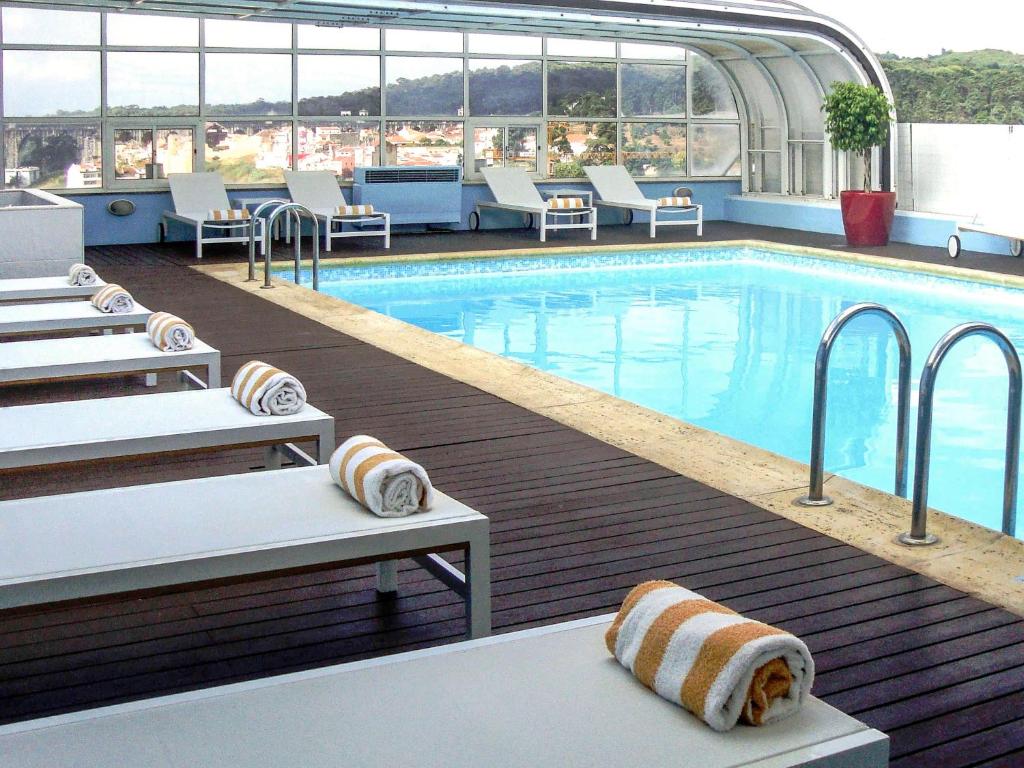 a swimming pool with lounge chairs and a swimming pool at Hotel Mercure Lisboa in Lisbon