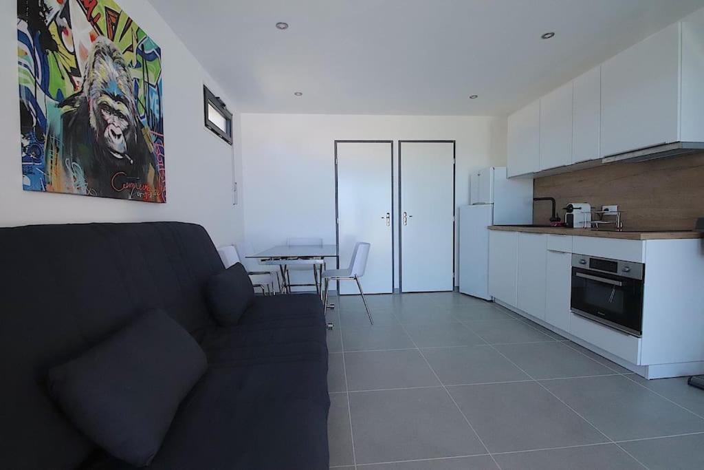 AlbitrecciaT2 VILLAS ACUM 4 pers-Agosta PLAGE- parking的一间厨房和一间带沙发和桌子的客厅