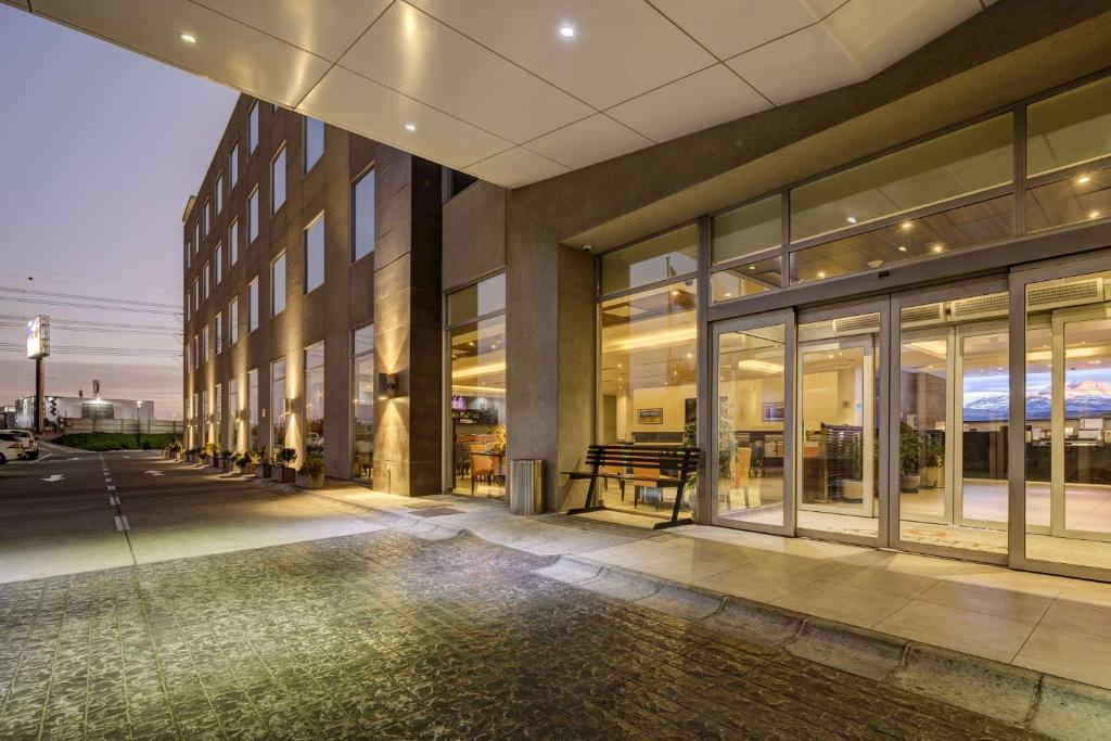 a building with glass windows and a sidewalk at La Quinta by Wyndham Santiago Aeropuerto in Santiago