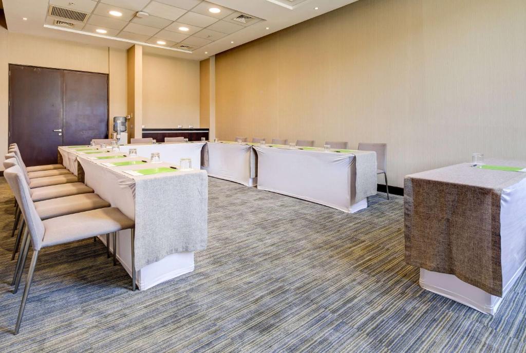 a conference room with a row of tables and chairs at La Quinta by Wyndham Santiago Aeropuerto in Santiago