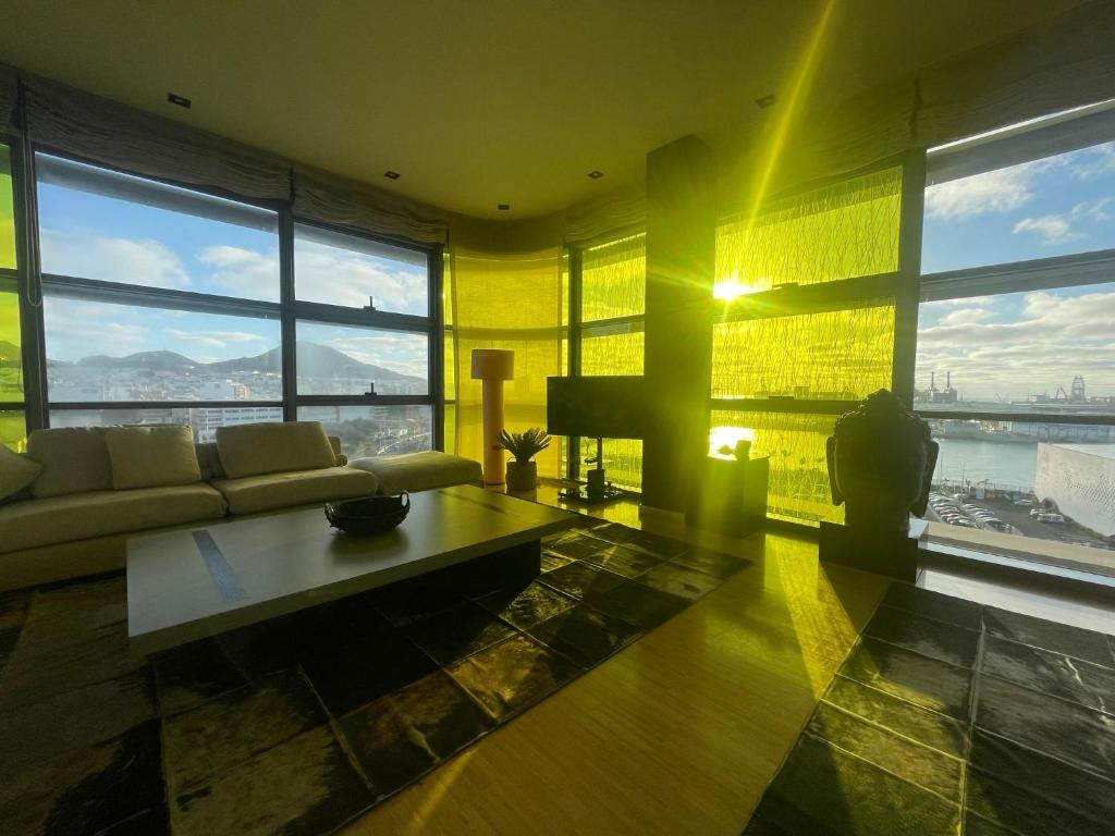 ein Wohnzimmer mit einem Sofa und großen Fenstern in der Unterkunft Luxury Family Beachfront Apartment in Las Palmas de Gran Canaria