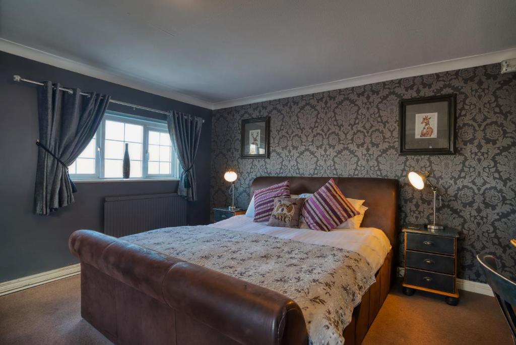 a bedroom with a large bed and a window at The Swan Inn in Bridgnorth