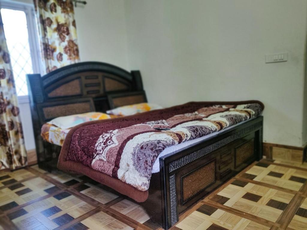 1 dormitorio con 1 cama con marco de madera en Gaharwar Home Stay, en Dehradun