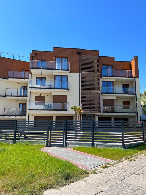 a building with a fence in front of it at Baltic Vip Nowe Apartamenty blisko plaży in Rewal