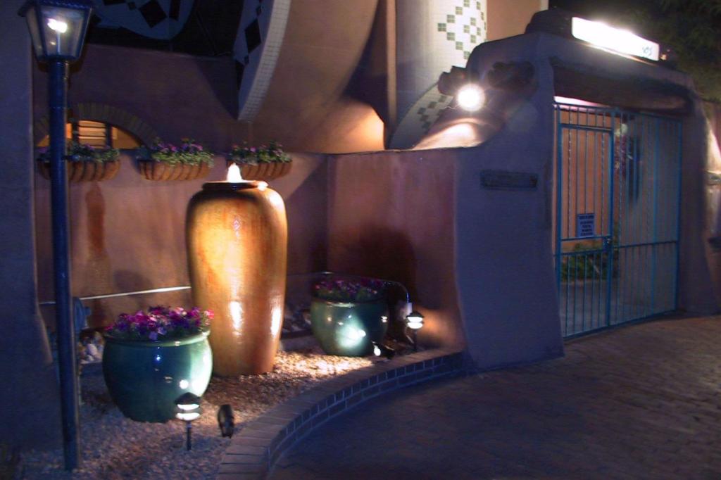 eine beleuchtete Gasse mit Topfpflanzen und einer Kerze in der Unterkunft Casas de Suenos Old Town Historic Inn, Ascend Hotel Collection in Albuquerque