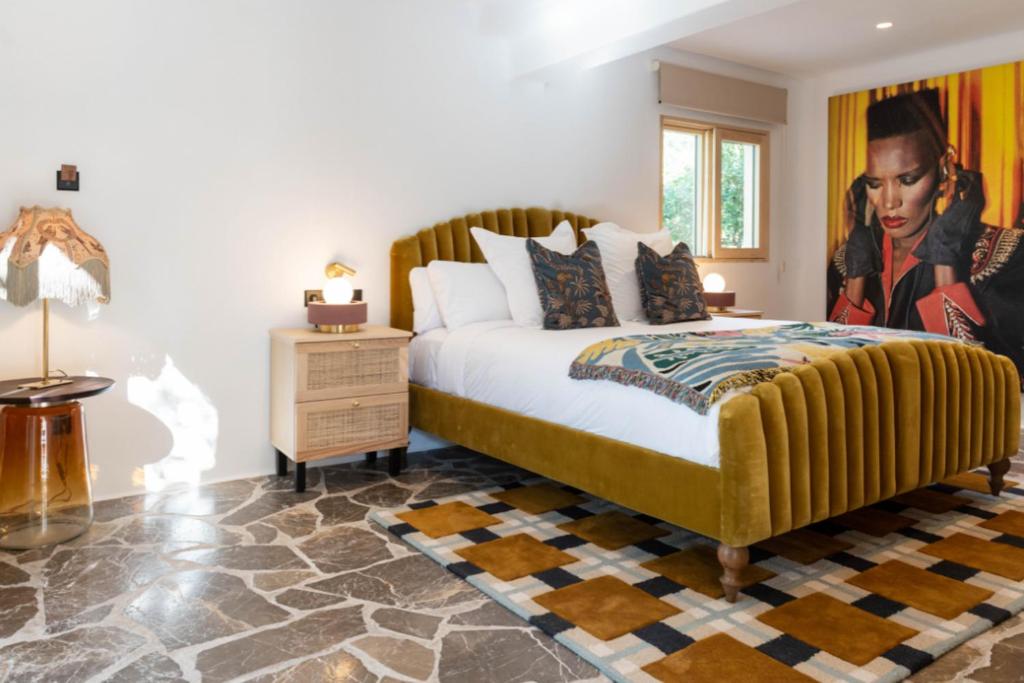 a bedroom with a king sized bed with a painting on the wall at Pikes Ibiza in San Antonio