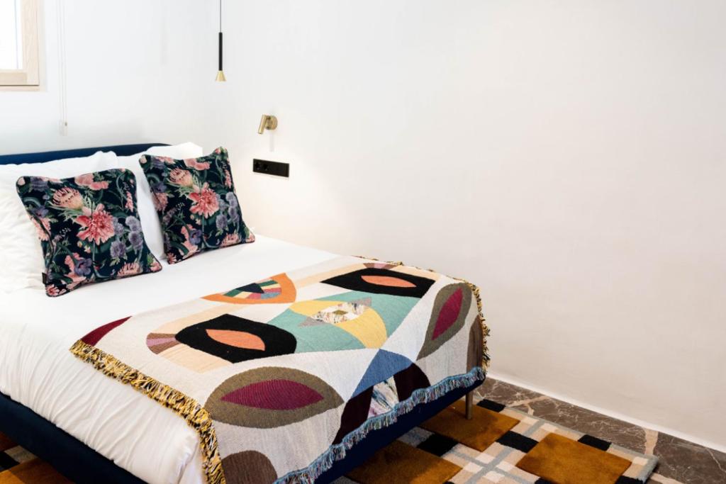 a bedroom with a bed with a colorful blanket on it at Pikes Ibiza in San Antonio