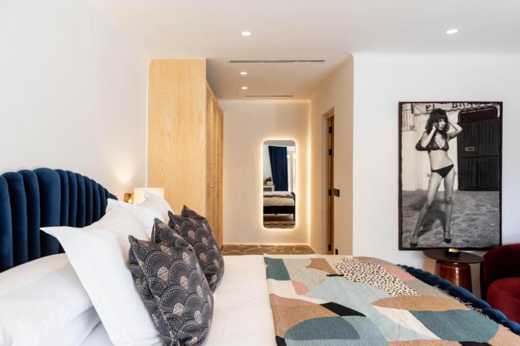 a bedroom with a bed with black and white pillows at Pikes Ibiza in San Antonio