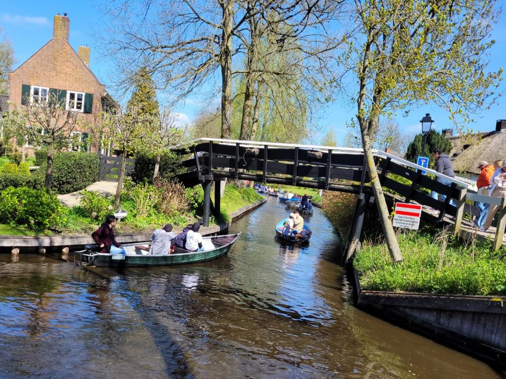Un groupe de personnes en bateau sur une rivière dans l'établissement B&B Villa Giethoorn - canalview, privacy & parking, à Giethoorn