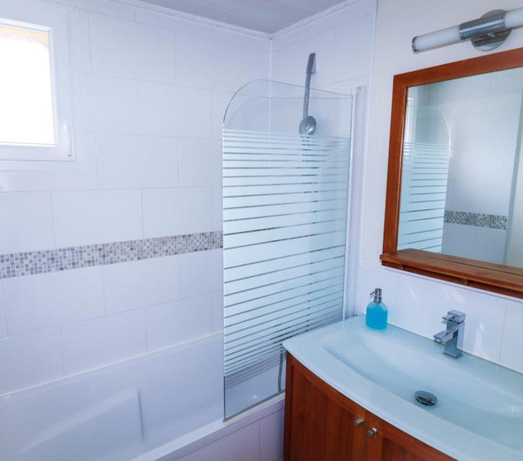 a white bathroom with a sink and a mirror at Village Drôles d&#39;Oiseaux in Le Teich
