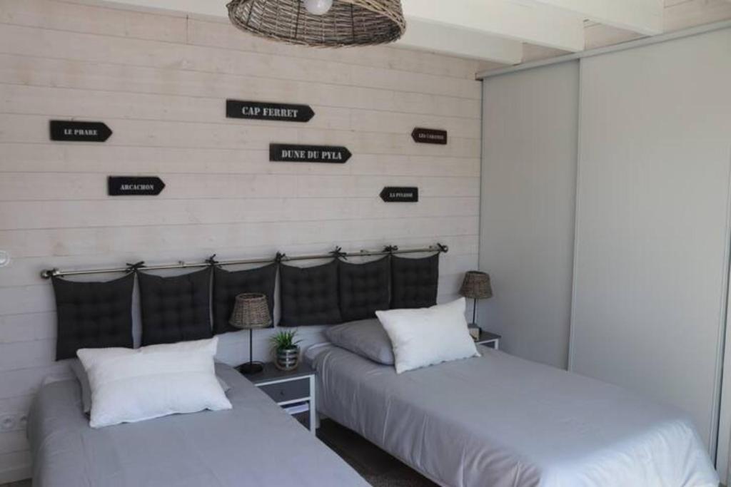 two beds in a room with signs on the wall at Village Drôles d&#39;Oiseaux in Le Teich