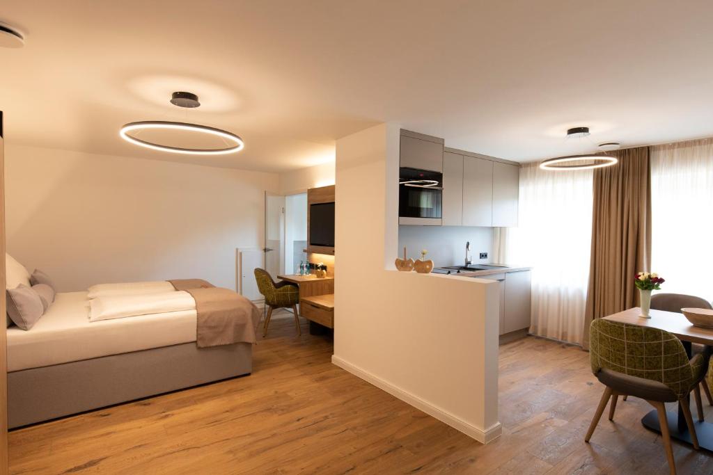 1 dormitorio con cama, mesa y cocina en Waldhotel am Wittenheimer Forst, en Westerstede