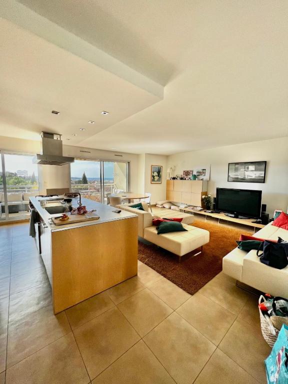 une grande chambre avec une cuisine et un salon dans l'établissement Antibes Maeva sea view swimming pool air conditioning and parking, à Antibes