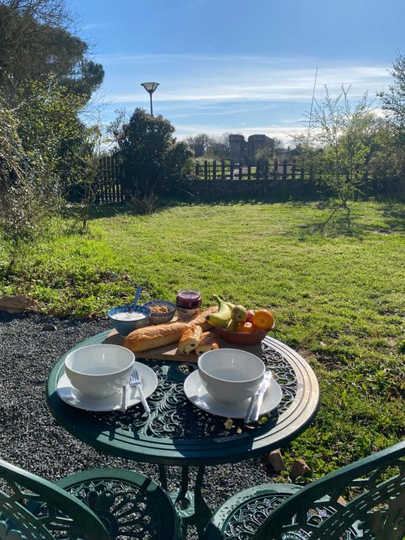 a table with two cups and a plate of food at Vue du chateau a La Petite Ferme d&#39;Alpacas in Sanzay