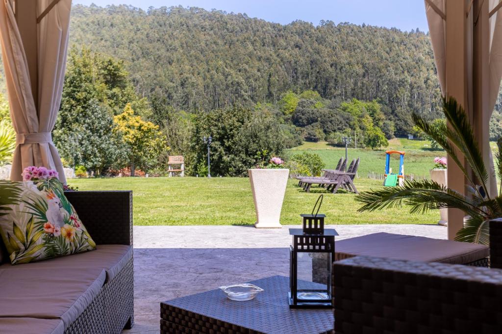 a patio with a couch and a table with a view at Posada El Trasmerano in Argoños