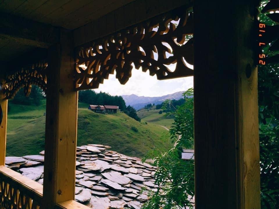 een raam met uitzicht op de bergen vanuit een hut bij Above the Clouds in Tusheti