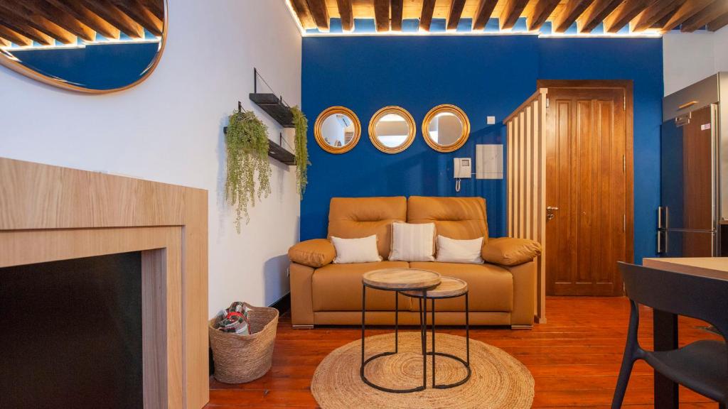 トレドにあるEl Patio del Regidor - Apartamentos Aloha Toledoの青い壁のリビングルーム(ソファ付)