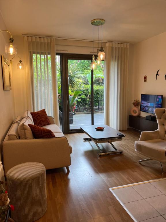 a living room with a couch and a table at Luxueux appartement 4 personnes - Parking gratuit - 20 min de Paris in Asnières-sur-Seine