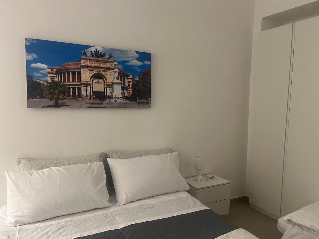 a bedroom with a bed with a picture on the wall at La casetta mape in Palermo