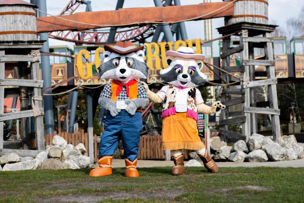 two mascots standing in front of a roller coaster at Vakantiepark Slagharen in Slagharen