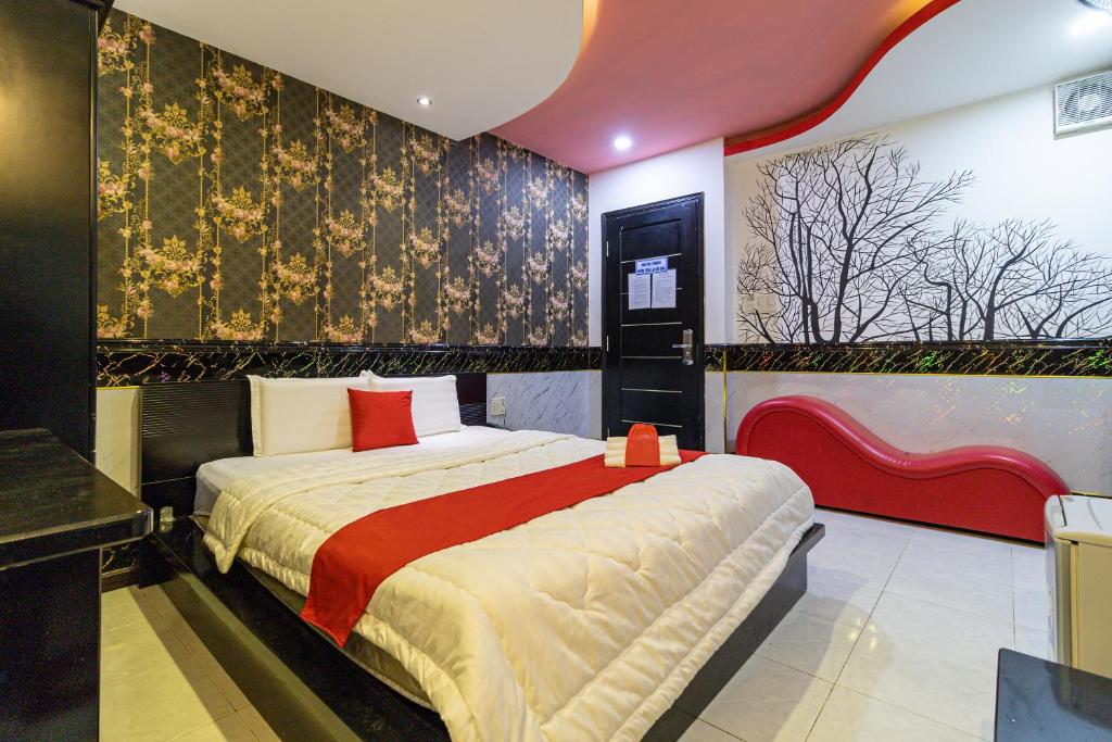 um quarto com uma cama grande e um cobertor vermelho em Thiem Thanh Hotel em Ho Chi Minh