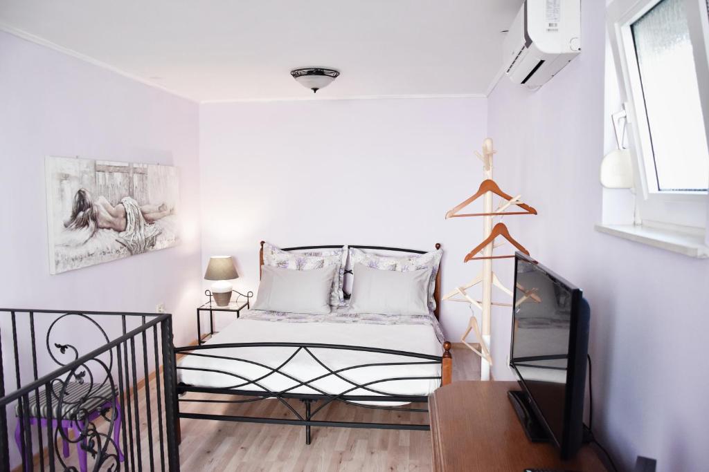 a small bedroom with a bed and a television at Lavender cozy & lovely 17 in Split