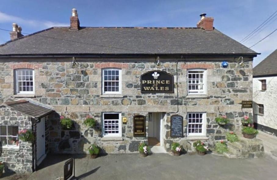 an old stone building with a sign that reads timber walks at The Prince of Wales in Helston