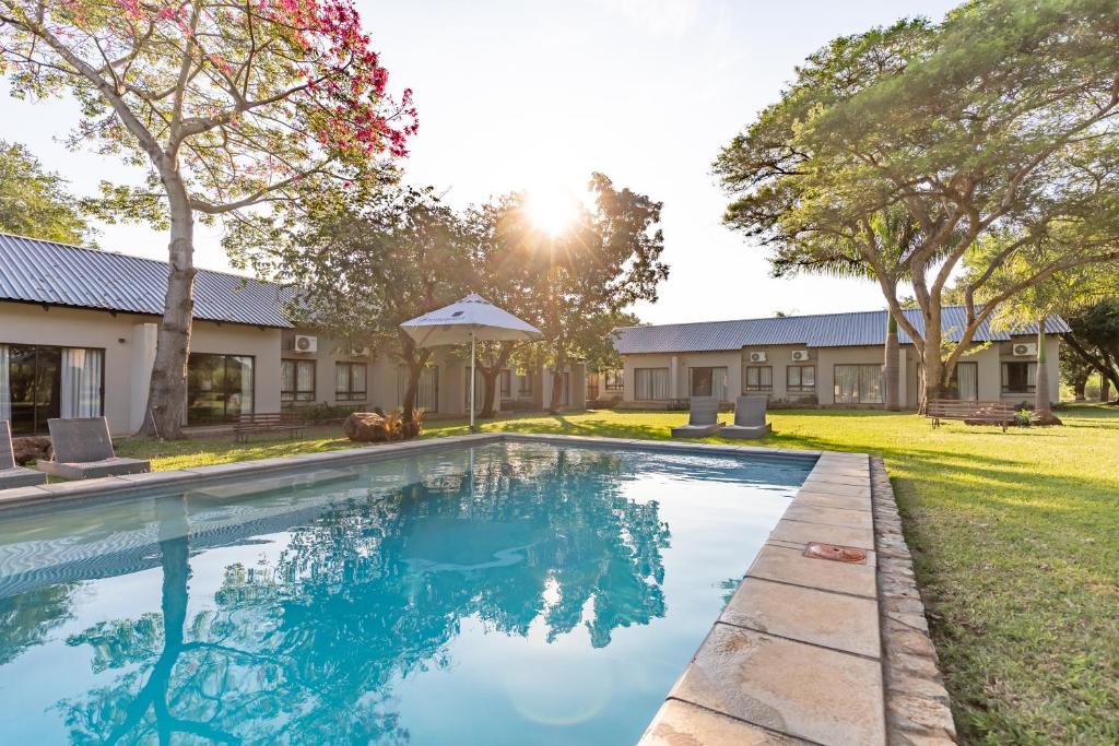 馬里蘭的住宿－Hamiltons Lodge & Restaurant，一座树木繁茂的房屋后院的游泳池