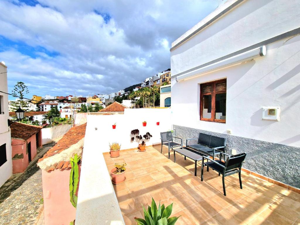 eine Terrasse mit zwei schwarzen Bänken auf einem weißen Haus in der Unterkunft Casa Fa & Na Garachico by HRTenerife Net in Garachico