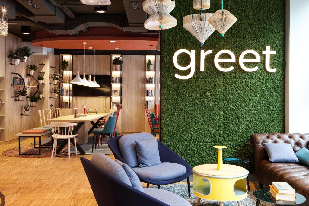 a store with chairs and a green wall with the word creep at greet Wien City Nord in Vienna