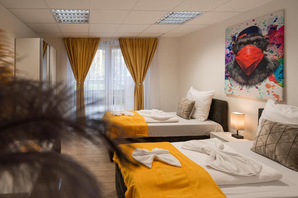 una camera d'albergo con due letti con lenzuola gialle di Cannstatter Hotel a Stoccarda