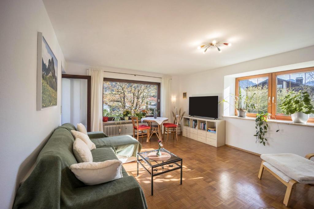 uma sala de estar com um sofá e uma televisão em Haus Bergliebe - Breitenbergblick em Pfronten