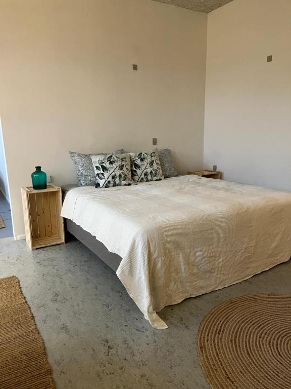 Room 6 - Hawkraft Kulturhotel في Vestervig: غرفة نوم بسرير كبير عليها شراشف ووسائد بيضاء