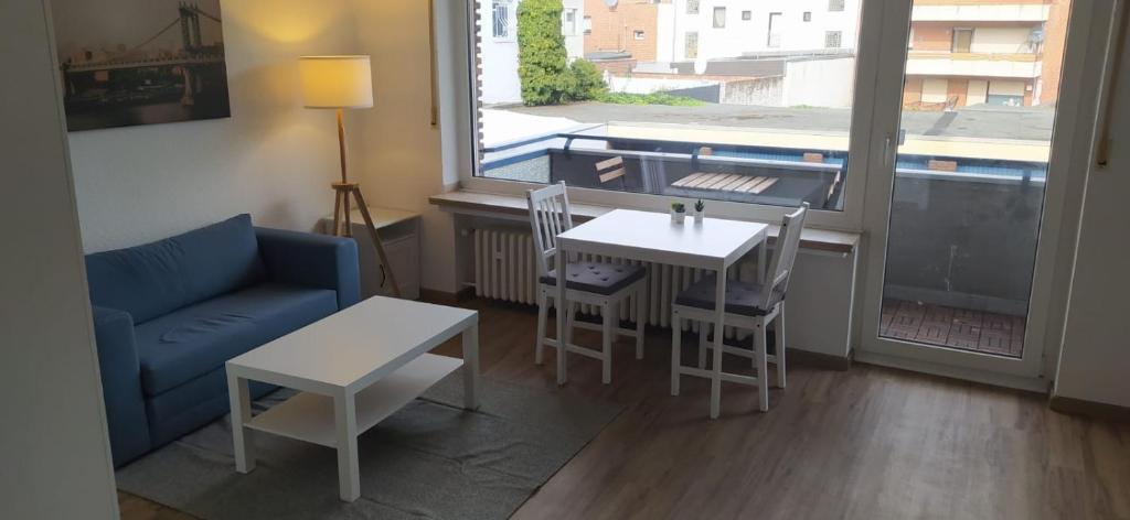 - un salon avec une table et un canapé bleu dans l'établissement Frisch renoviertes Appartement, à Mönchengladbach