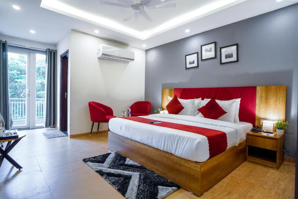 1 dormitorio con 1 cama grande y cabecero rojo en Saltstayz Hotel Huda City Center, en Gurgaon