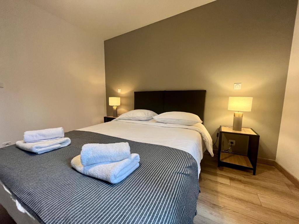 ein Schlafzimmer mit einem großen Bett mit Handtüchern darauf in der Unterkunft Maison moderne climatisée - DABNB in Limoges