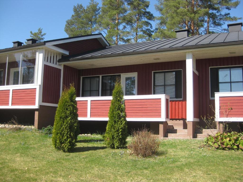 une maison avec une véranda rouge et blanche à l'avant dans l'établissement Rt-huoneisto,Kulnevintie 2 as 3, 62300 HÄRMÄ, à Härmä