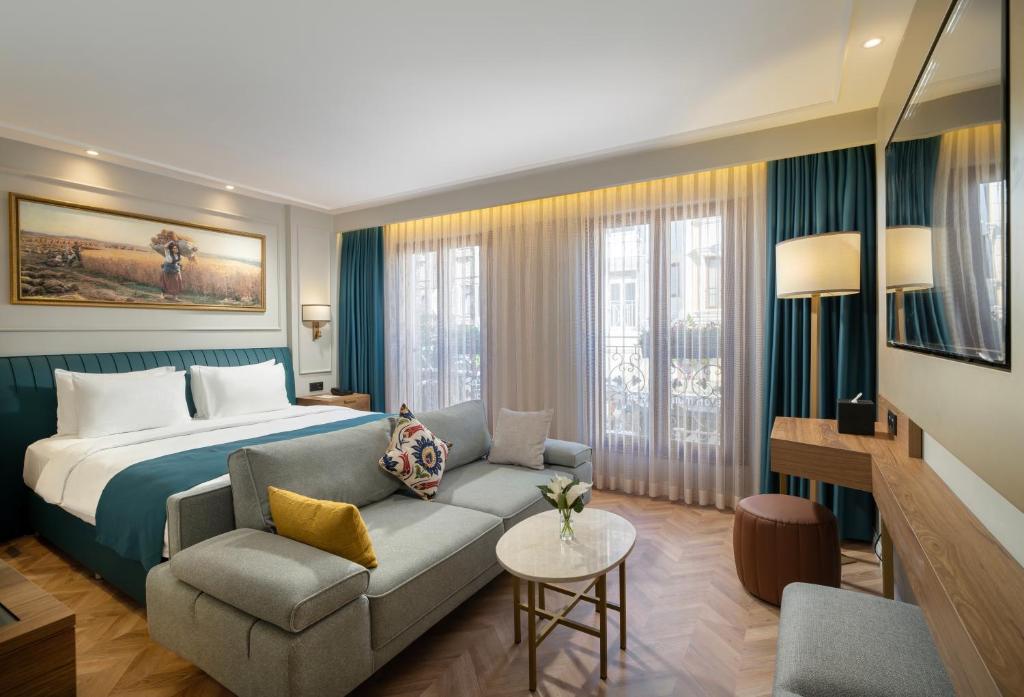 Habitación de hotel con cama y sofá en Royan Suites, en Estambul